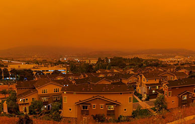 Homes under hazy orange sky