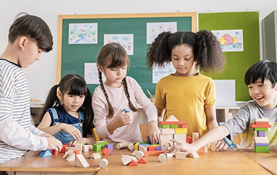 Group of schoolchildren building with blocks
